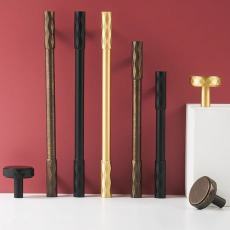 "Assortment of modern faceted brass knobs and pull bars in various finishes with a diamond-cut texture, suitable for contemporary and classic interiors."