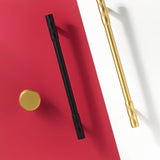 "Modern black and gold faceted brass knobs and pull bars with a diamond-cut texture, suitable for contemporary and classic interiors."