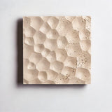 "A square travertine wall lamp with a textured hexagonal surface, isolated on a white background, showing the natural stone pattern."