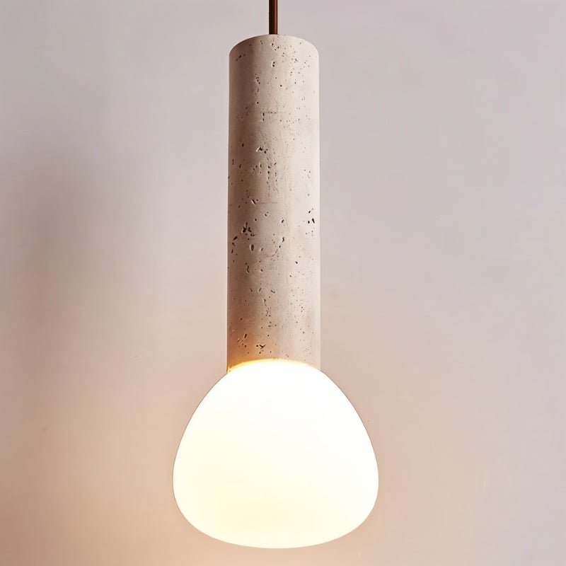 "Close-up of a cylindrical travertine pendant light with a frosted glass diffuser."