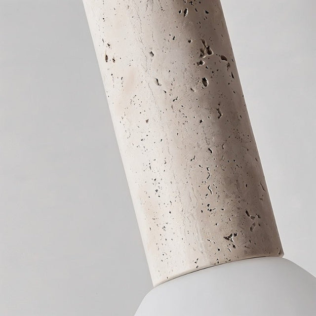 "Close-up of the textured travertine body of a pendant light."