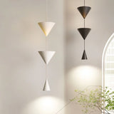 "Modern pendant lights with stacked conical shades in black and white finishes in a contemporary living room."