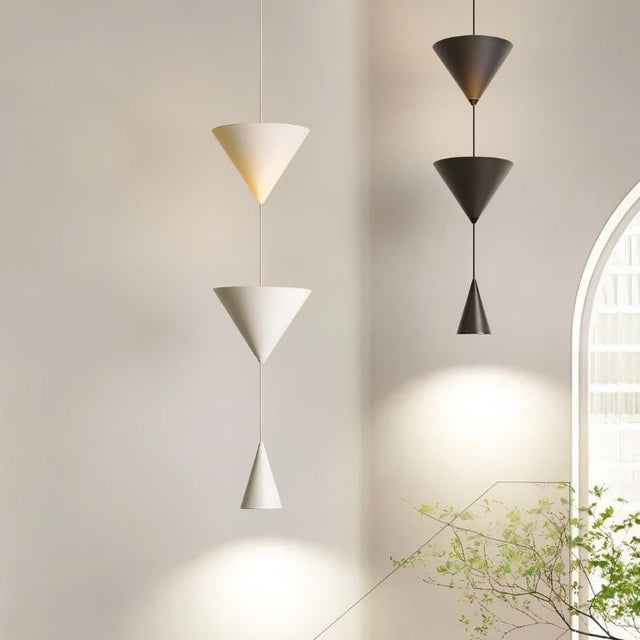 "Modern pendant lights with stacked conical shades in black and white finishes in a contemporary living room."