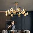 "A modern chandelier with circular glass accents and a gold metal frame hanging in a contemporary living room."