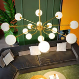"A gold chandelier with multiple frosted glass globes, hanging above a living room sofa."
