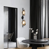 "Modern wall lamp with smoked glass shades and a black rod, illuminating a contemporary dining room."