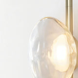 "Close-up of a clear glass shade on a modern wall lamp, showing its elegant design and soft illumination."