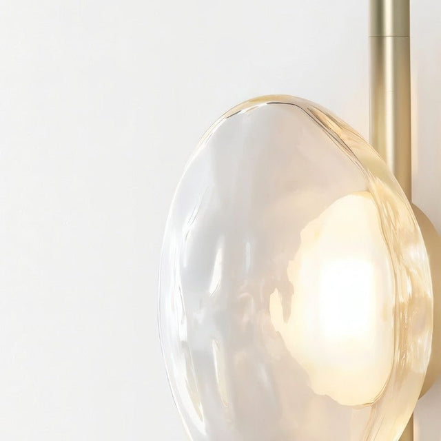 "Close-up of a clear glass shade on a modern wall lamp, showing its elegant design and soft illumination."
