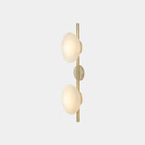 "Modern wall lamp with two frosted glass shades on a vertical rod, providing soft, ambient lighting."