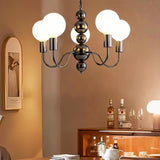 "Walfi chandelier with iron frame and frosted glass globes hanging in a dining room with a cabinet and decorative items."