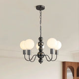 "Walfi chandelier with iron frame and frosted glass globes hanging in a dining room with a cabinet."