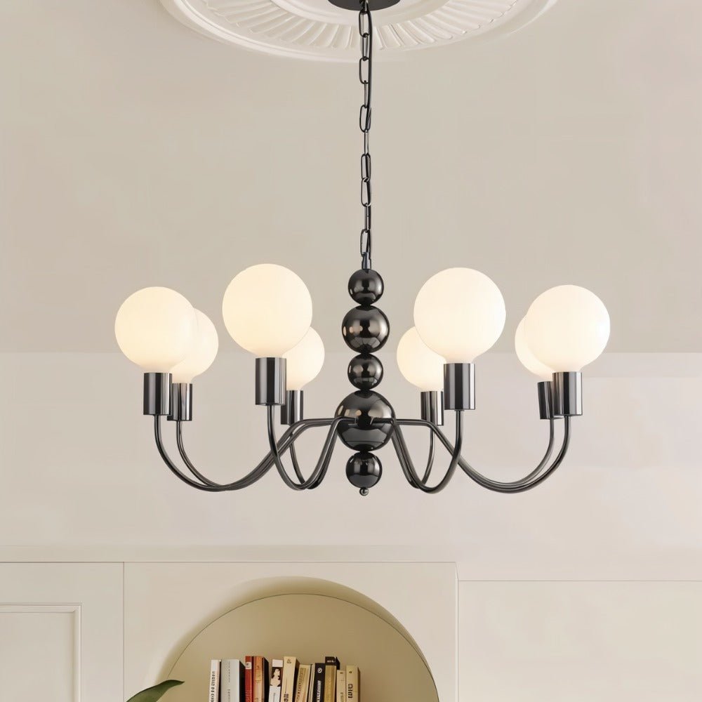 "Walfi chandelier with iron frame and frosted glass globes hanging in a living room with a bookshelf."