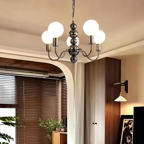 "Walfi chandelier with iron frame and frosted glass globes hanging in a living room with blinds and plants."
