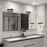 "Two modern, curved LED wall lamps illuminating a double sink bathroom vanity with mirrors."