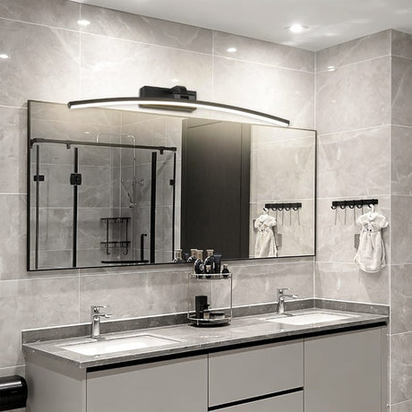 "A modern, curved LED wall lamp illuminating a bathroom vanity with a double sink and mirror."