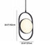 Black metal pendant light with cream-colored circular diffuser, suspended against white background.
