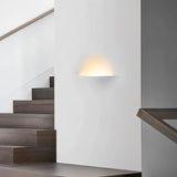 "Wiane trimless wall light illuminating a modern staircase."