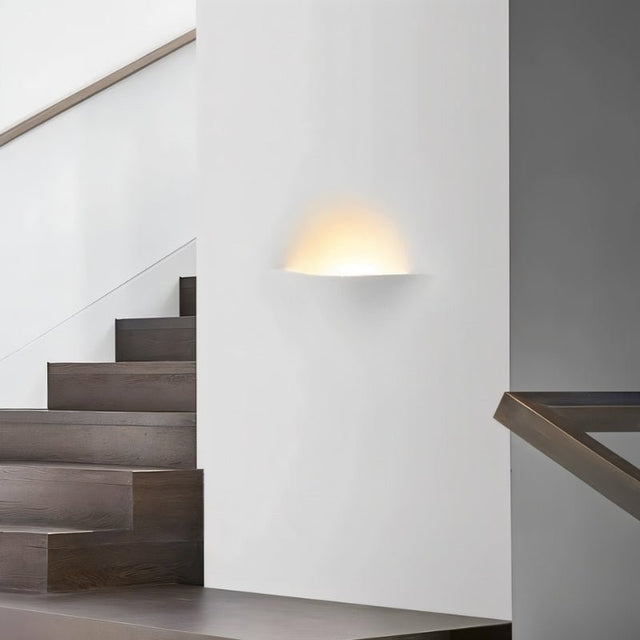 "Wiane trimless wall light illuminating a modern staircase."