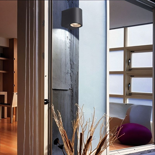 "A modern outdoor wall lamp illuminating a contemporary home exterior with a soft, focused light."