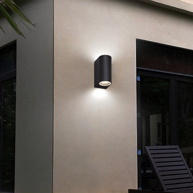 "A modern outdoor wall lamp illuminating a patio area with a focused beam of light."