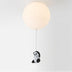 Pendant ceiling light with cream glass globe and black-and-white panda figurine hanging from thin metal rod against white background.