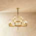 Chandelier with eight cylindrical glass shades, metal frame, shown from front view against white background with dimension de