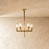 Five-light cylindrical glass chandelier with brushed nickel finish on white background, front view.