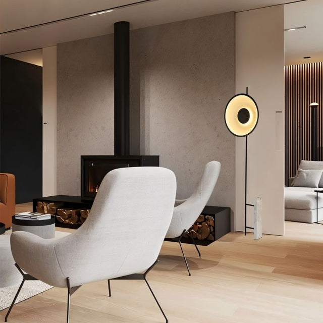 "A halo floor lamp with a sculptural design, illuminating a modern living room with contemporary furniture and a fireplace."