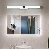 "A silver wall lamp with a linear LED bar illuminating a modern bathroom with a rectangular mirror reflecting a shower curtain and a round sink below."