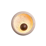 "A minimalist, circular travertine wall lamp with a warm wooden centerpiece, isolated on a white background."