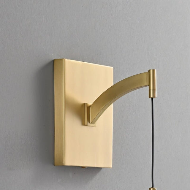 "Close-up of a modern brass wall lamp featuring a rectangular backplate and a gently curved arm, showcasing its sleek design and elegant craftsmanship."