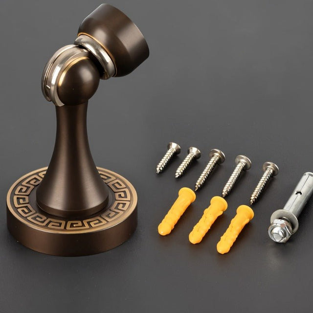 "Elegant, sculpted brass door stop with a tapered design, shown with included screws and anchors for installation, designed to prevent wall damage in modern and classic interiors."