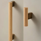 "Minimalist wood and brass knobs and pull bars on a contemporary cabinet, showcasing a sleek, functional design."