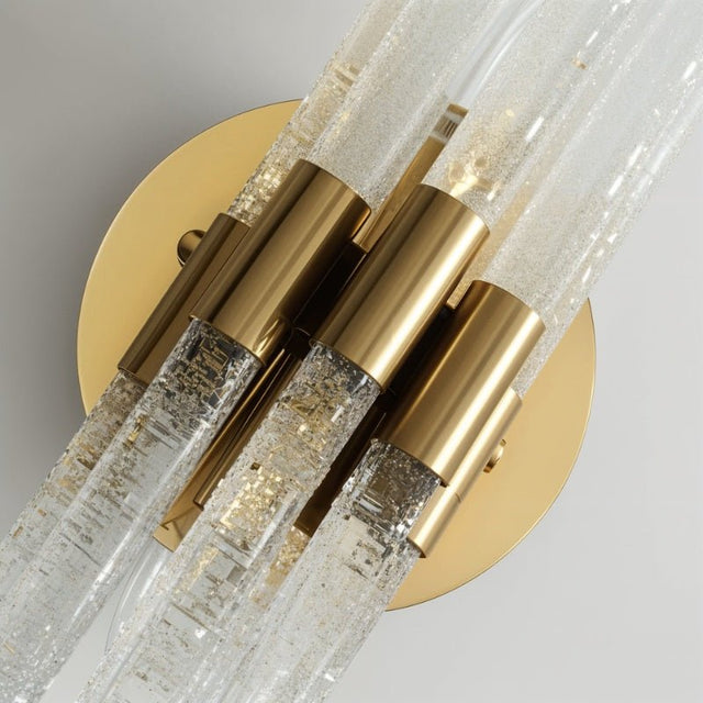 "Close-up of a modern brass wall lamp with textured glass rods showing detail."