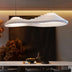 White wavy modern pendant light hanging above a marble countertop in a contemporary interior setting.