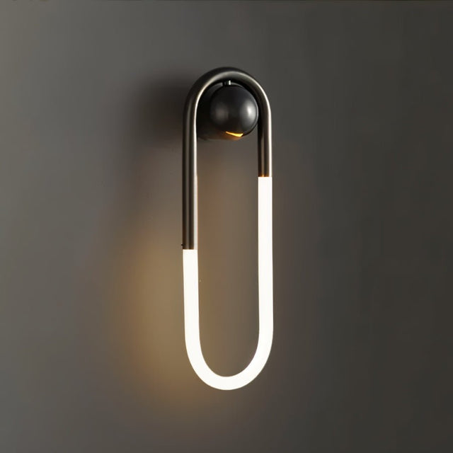 "A modern, minimalist U-shaped black wall lamp emitting a soft, warm light."