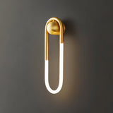 "A modern, minimalist U-shaped wall lamp with a brass finish."