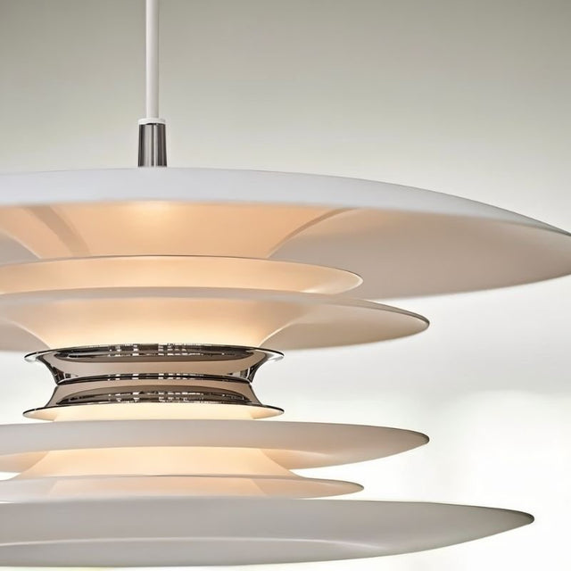 "A close-up view of a modern pendant light with layered white discs and silver accents, highlighting the textured design and soft illumination."