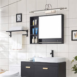 "A silver wall lamp with decorative end caps mounted above a modern black bathroom vanity with a mirror, shelves, and a white sink, against a tiled wall."