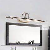 "A silver wall lamp with decorative end caps mounted above a modern grey framed bathroom mirror, reflecting toiletries on a shelf."