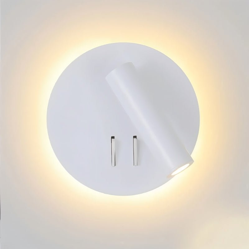 "Close-up of a modern white wall-mounted reading lamp with a circular backplate and adjustable cylindrical spotlight, showcasing its minimalist design and ambient lighting."
