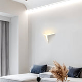 "A lit white trimless wall light with a geometric design on a white wall above a couch in a modern living room."