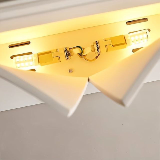 "A close-up view of a lit white trimless wall light, showing the internal light source and geometric design."