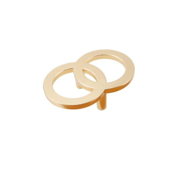 "A brushed gold knob with two interlocking circles, made of zinc alloy, isolated on a white background."