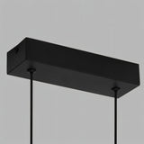 "Close-up detail of the rectangular canopy of a modern LED pendant light with thin suspension cables."