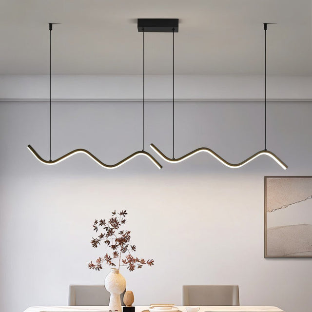 "A modern LED pendant light with fluid, wave-like bars, illuminating a dining room with a table and chairs."
