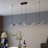 "A modern LED pendant light with fluid, wave-like bars, illuminating a dining area with contemporary decor and art pieces."