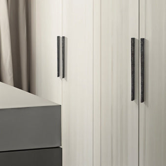 "Modern hammered texture pull bar handles on a light wood wardrobe, blending a handcrafted aesthetic with contemporary design."