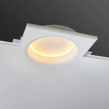 "A round, recessed ceiling light casting a warm, lunar-like glow, installed in a white ceiling above a modern bedroom."