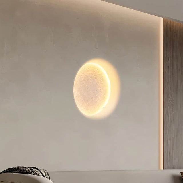 "A round, warm light effect on a wall, created by a recessed trimless downlight, resembling a moon."